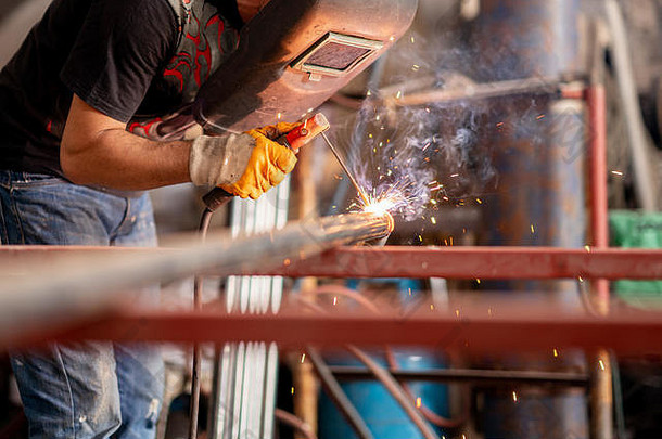 金属工人在自己的保护下焊接金属。