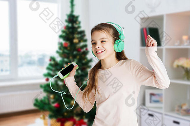 圣诞节带着智能手机和耳机的女孩