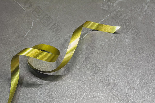皮革桌子背景上的金色螺旋丝带。
