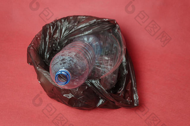 塑料<strong>透明</strong>的空瓶黑色的袋容器红色的背景空间文本概念环境污染塑料