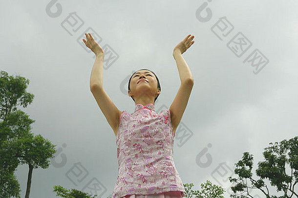 一位中年女子练习太极拳的低角度照片