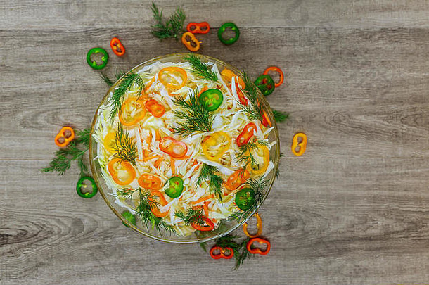 在一张古老的乡村桌子上，<strong>白</strong>色盘子上放着健康的低热量春菜沙拉，配上甜椒、玉米和莳萝，从上面俯瞰