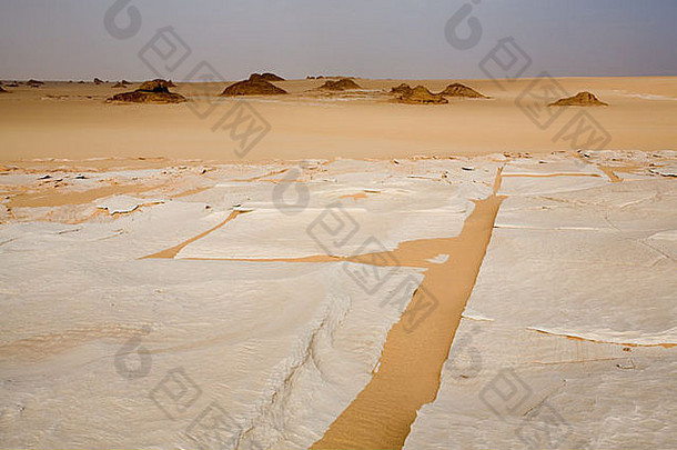 沙漠地面上白色石灰岩形成作物的路面特写。在前往撒哈拉沙漠吉尔夫·凯比尔的途中。埃及
