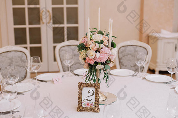 用白色和粉色玫瑰、康乃馨和蜡烛装饰婚宴桌