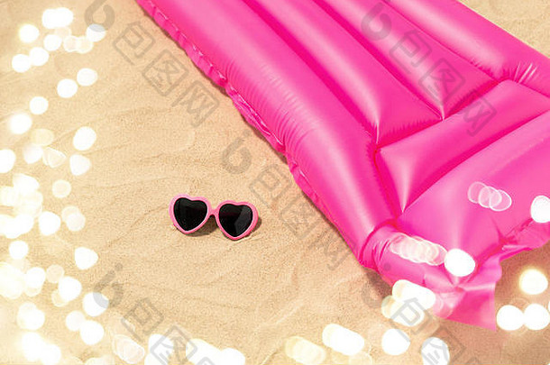 沙滩上的太阳镜和粉色游泳床垫