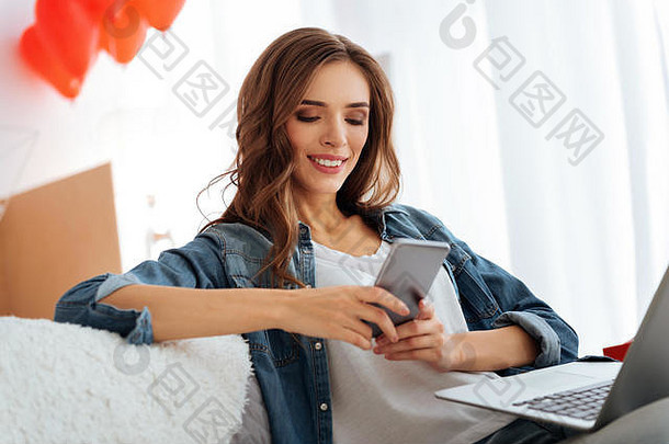 微笑的年轻女子在家里使用智能手机
