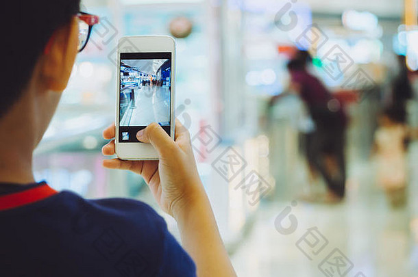 手持智能手机或手机的人在购物中心拍照。购物中心最受欢迎的地方和步行的方式与幸福。