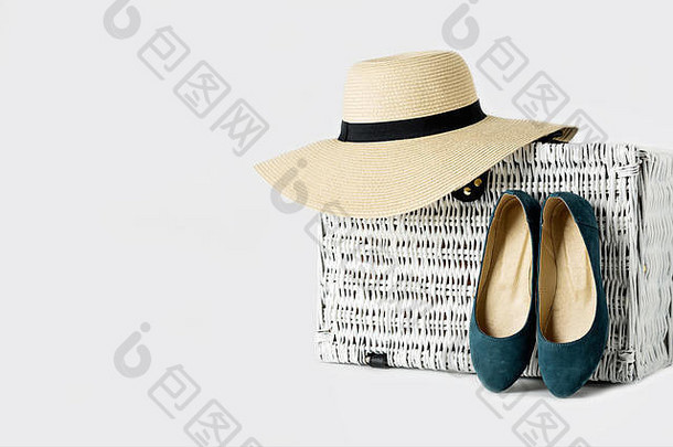 白色柳条手提箱，一顶女帽和一双蓝鞋。