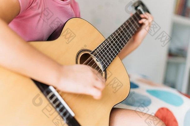 可爱的渐变女孩粉红色的t恤玩吉他坐床上明亮的房间首页关闭