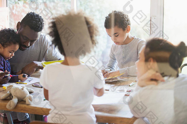 年轻的家庭成员在餐桌上涂色