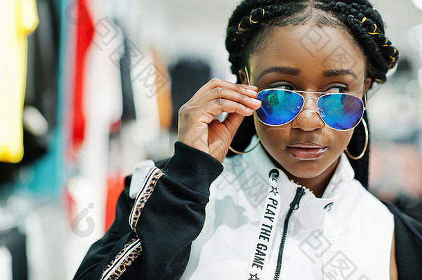 穿着运动服和太阳镜在运动服装<strong>商场</strong>购物的<strong>美</strong>国黑人妇女。运动商店<strong>主题</strong>。