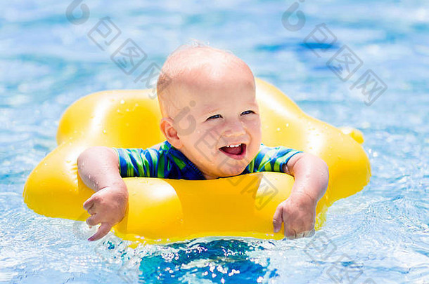 炎炎夏日，快乐的小<strong>宝宝</strong>在室外游泳池里玩着五颜六色的充气戒指。孩子们学习游泳。