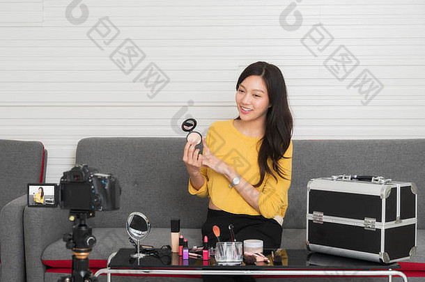 美博主美丽的年轻的女人穿黄色的衬衫坐着前面数码单反相机相机记录视频剪辑审查化妆化妆品侦察