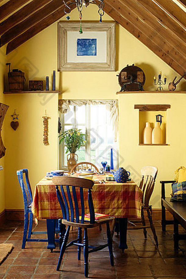 乡村餐厅的蓝色桌椅，配橙色格子布，顶部有横梁天花板和木制底座