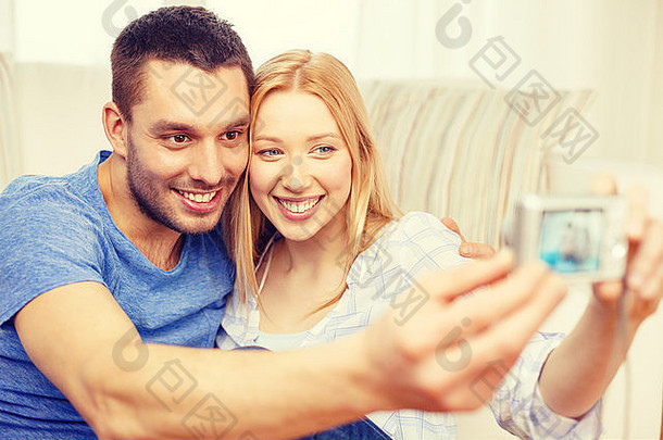 微笑的情侣用数码相机拍照