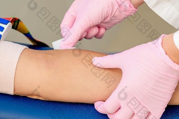 在医疗中心注射疫苗前，护士手正在消毒手臂皮肤。