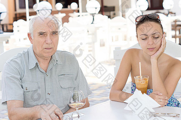 上了年纪的男人。美丽的年轻的女人坐着饮料餐厅户外表格热夏天一天