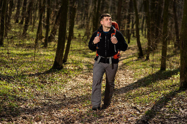 男子在户外森林中使用<strong>登山杖</strong>和杆子。