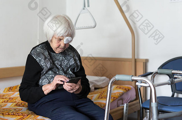 朗利是一位95岁的老妇人，她坐在床边，用的是现代手机。