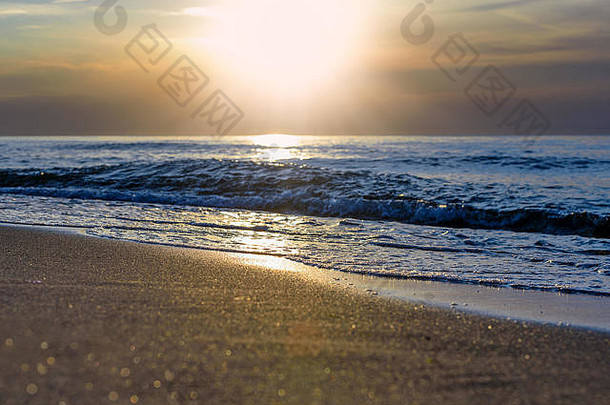 夕阳反射在海浪和海滩上的沙粒中，产生波克效应。