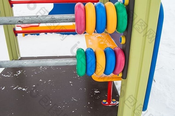 大彩色的孩子们的算盘塑料环金属帧冬天操场上覆盖雪