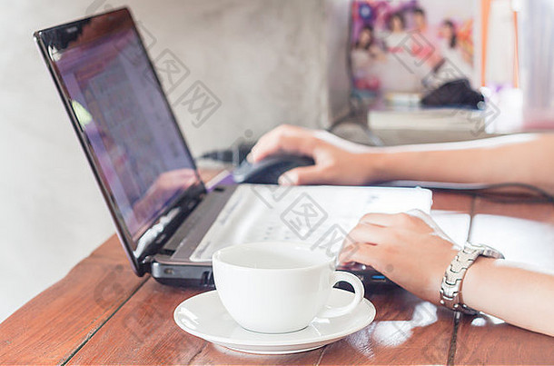 女人用笔记本电脑喝咖啡，拍照片
