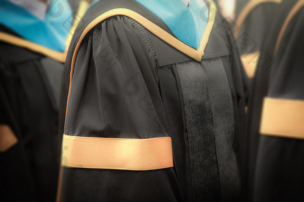在毕业典礼上选择学士学位毕业生的礼服，隐喻教育，成功，概念，背景