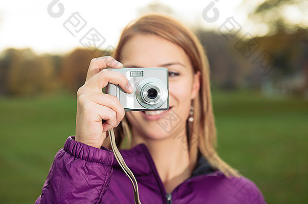 年轻迷人的女子手持照相相机拍摄的肖像