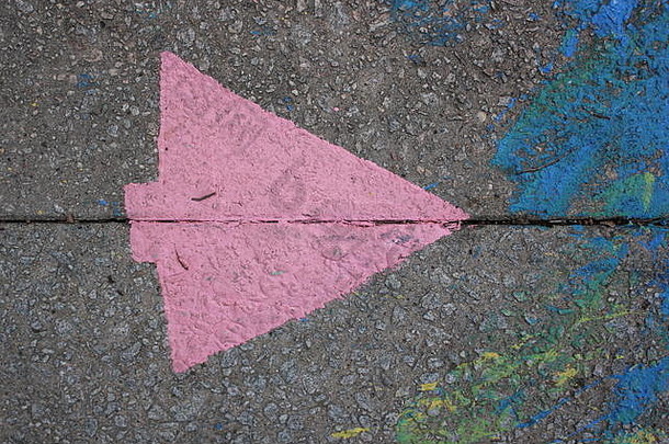 人行道上溅起了蓝色和黄色的油漆，还有一支刻有粉色箭头的钢印。