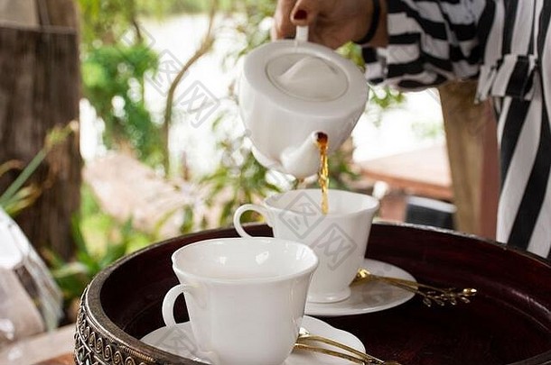 泰国度假酒店餐厅室外餐厅的餐厅露台上为游客和客人准备的茶点开胃菜和茶壶杯