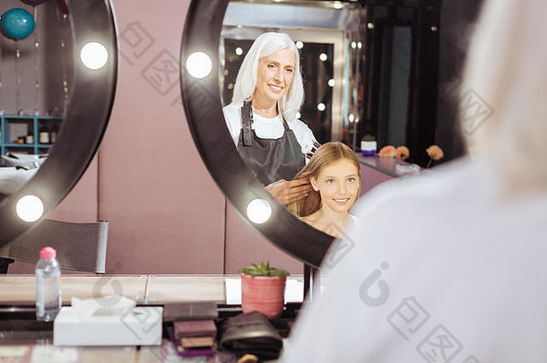 高级美发师为她十几岁的客户编辫子