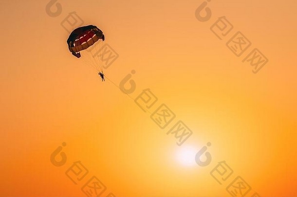 滑翔伞运动员飞行色彩斑斓的降落伞日落日出天空活跃的爱好阳光