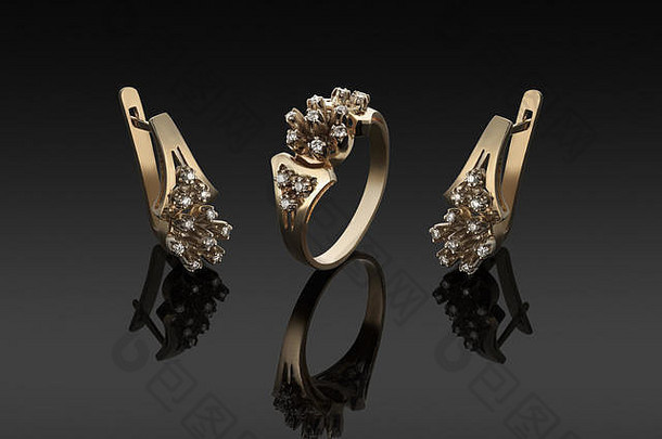深色背景上镶有钻石的金戒指和耳环