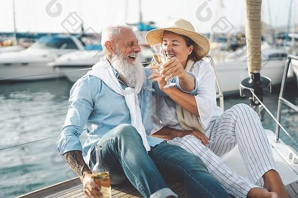 高级夫妇敬酒香槟帆船假期快乐上了年纪的人有趣的庆祝婚礼周年纪念日船旅行