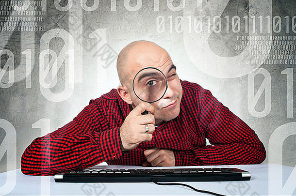 二进制搜索概念男人。坐着电脑表格键盘持有放大玻璃