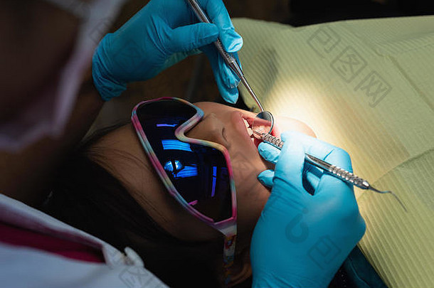 女牙医用工具检查病人