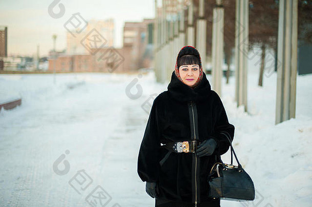 冬季城市环境中一位穿着保暖服装、戴着传统头巾的成年妇女的肖像