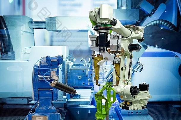 工业机器人在智能工厂、机器蓝色调背景、工业4.0和技术上与车辆的汽车部件一起工作。