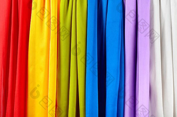 垂直的彩色缎子窗帘。红色、黄色、绿色、蓝色、紫色和灰色缎纹窗帘。
