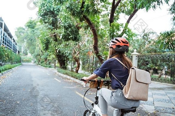 亚洲年轻的女人穿头盔袋骑<strong>折叠自行车</strong>路