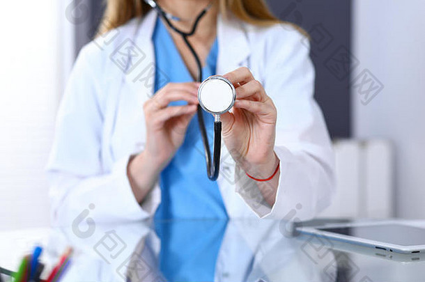女医生拿着听诊器的头，双手贴近。医生准备检查和帮助病人。医疗保健、最佳治疗和药物概念中的医疗帮助和保险