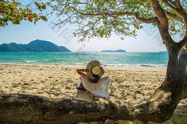 在泰国的热带海滩上，一名女子在横渡中享受假期