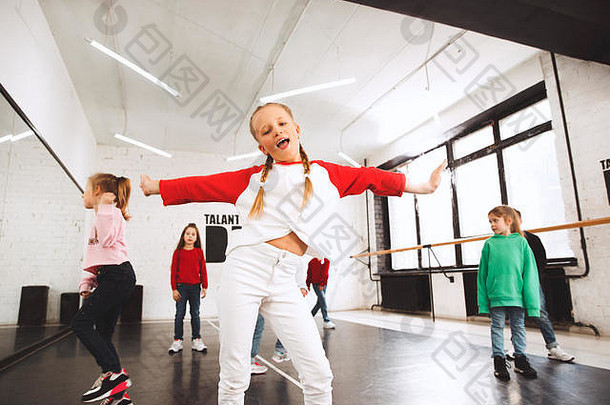 舞蹈学校的孩子们。芭蕾舞、嘻哈、街头、时髦和现代舞者在工作室背景下表演。儿童表现出有氧元素。嘻哈风格的青少年。运动、健身和生活方式概念。