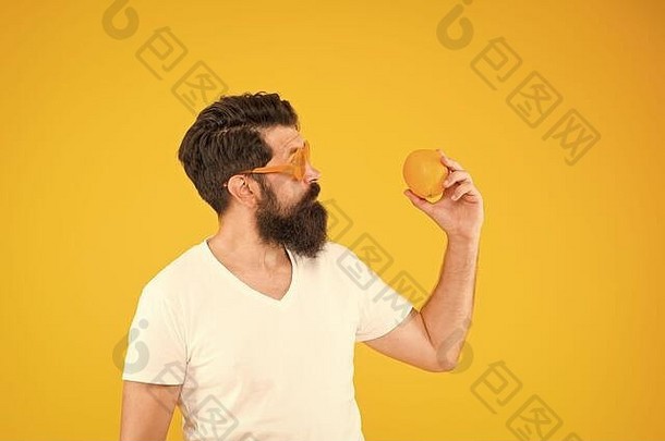 <strong>享</strong>受节食的滋味吧。节食<strong>专</strong>家拿着黄色背景上的橘子。留胡子的男人吃柑橘类水果。节食<strong>日</strong>的健康食品。