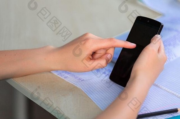 在虚拟教室里，美丽的少女在家里用智能手机学习，用手机在手上特写。距离