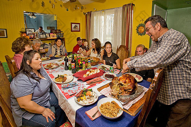 一位西班牙裔父亲在感恩节晚餐上切火鸡