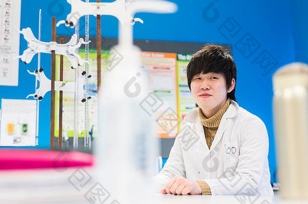 一位年轻的海外亚洲大<strong>学生</strong>在科学实验室里做了一个实验。