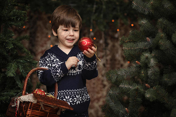 新年树旁的一个小孩。孩子们装饰圣诞树