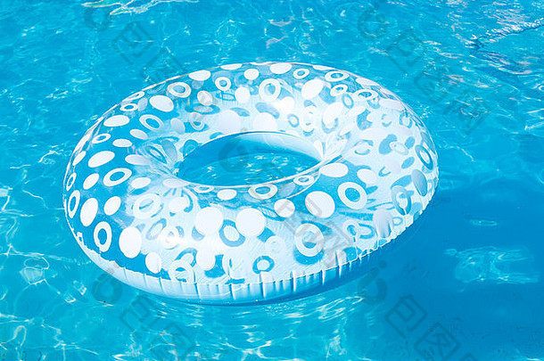 夏季露天游泳池中的蓝色充气游泳圈