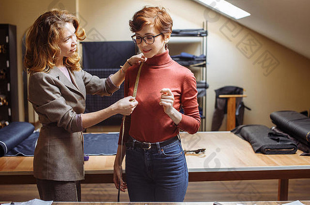 女裁缝选择织物模式切割男人的穿行业裁剪过程概念